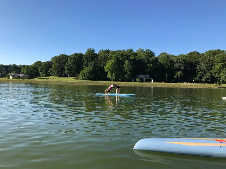 person doing stand up paddle board yoga demonstration